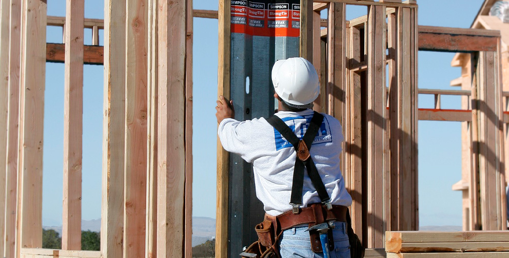 Unfinished wooden framed structure at a construction site with multiple Strong-Wall Shearwalls installed throughout the wooden structure.