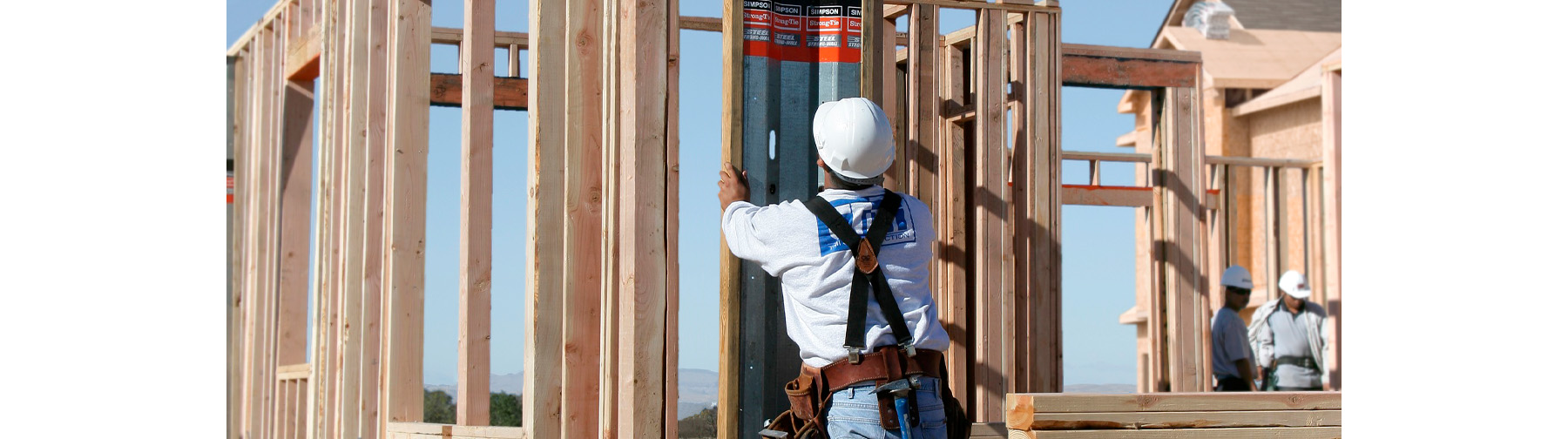 Unfinished wooden framed structure at a construction site with multiple Strong-Wall Shearwalls installed throughout the wooden structure.