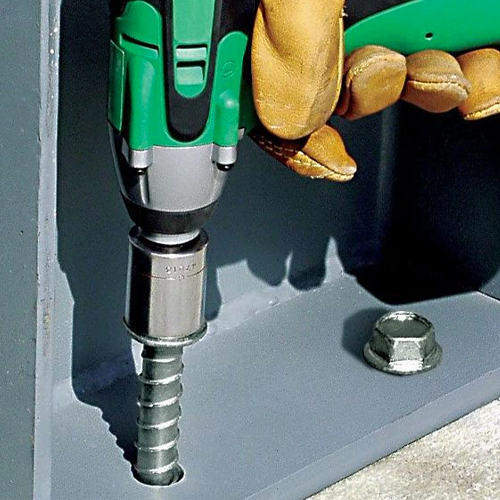 Yellow gloved hand drilling Titen screw into mechanical anchor