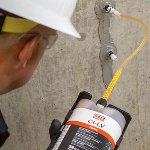 Construction worker injecting Simpson Strong-Tie CI-LV epoxy into concrete for crack repair and structural reinforcement.