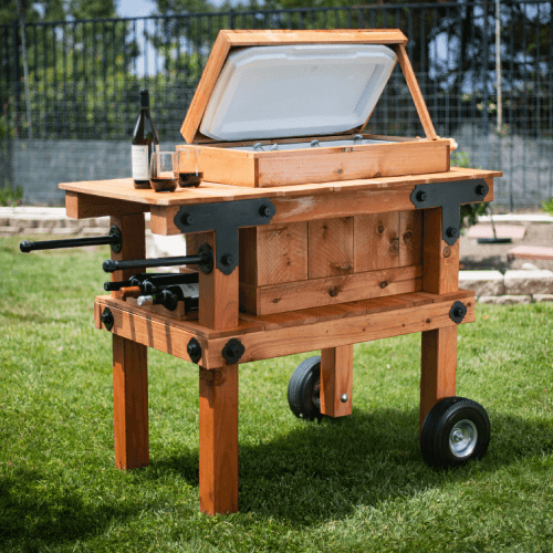 Homemade mobile outdoor cooler cart with two glasses on wine on it.