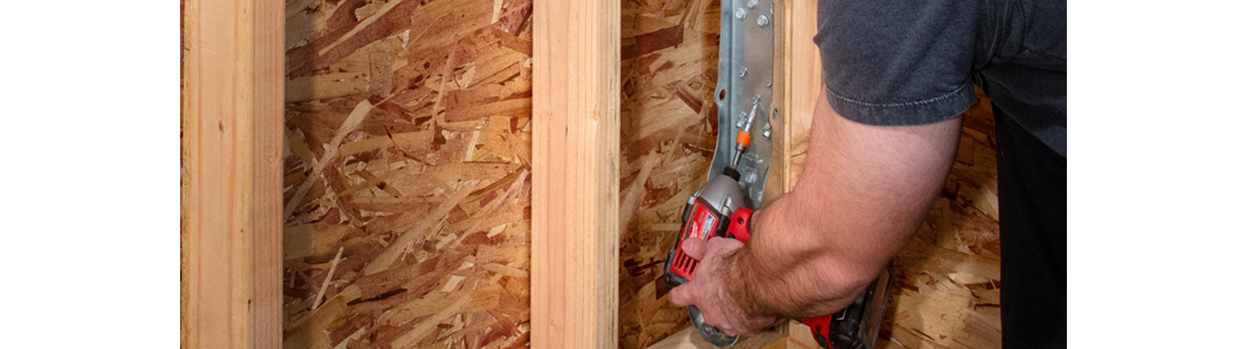 Man using red drill gun to install HDUE7 product into wooden panel.