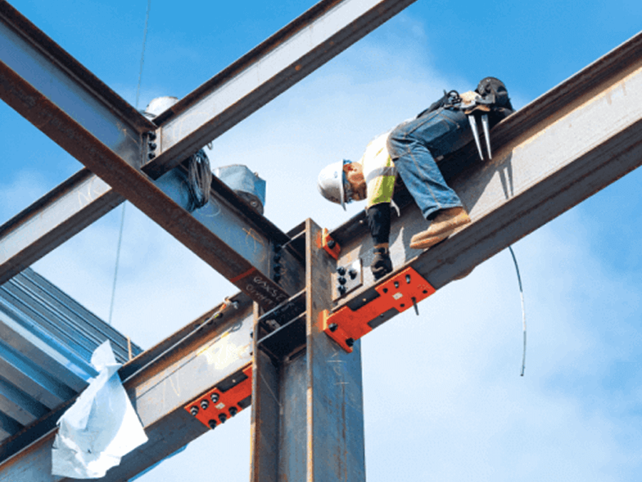 Construction worker wearing safety gear and harness installs steel beams at a high-rise structure against a clear blue sky, using bolts and orange connectors for support.
